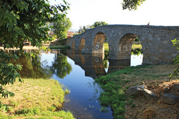 Fototapeta na wymiar Old arched bridge over river, Spain