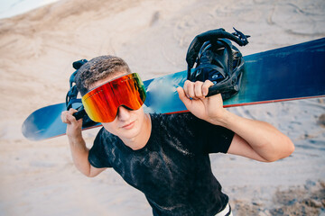 Snowboarder man sand boarding on dunes in Dubai, UAE