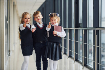 School kids in uniform together in corridor. Conception of education