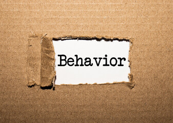 The text BEHAVIOR. behind torn brown paper