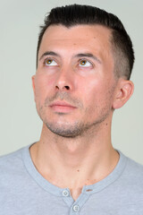 Fototapeta premium Portrait of young handsome man thinking and looking up