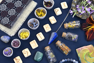 Mystic still life with tarot cards, runes, crystal and bottles with elixir on witch table.