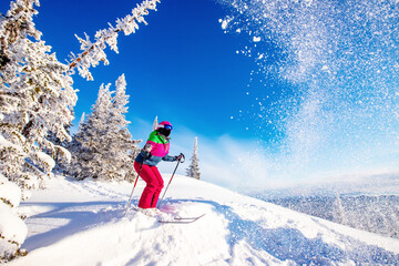 Young woman ski jumping from springboard in snowy forest off-piste, winter extreme sport concept