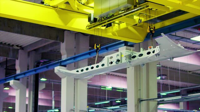 Overhead industrial crane moving inside an aircraft factory