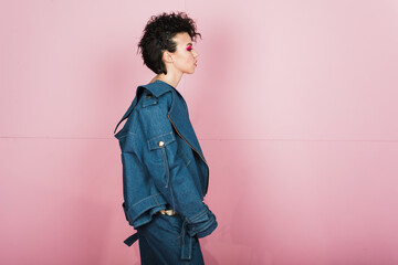 Portrait of a woman with bright flying hair. Beautiful lips and makeup. Hair fluttering in the wind. Sexy girl with short hair. Profile portrait of a young girl in a jeans suit 