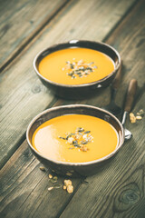 Pumpkin soup on wooden table, space for text