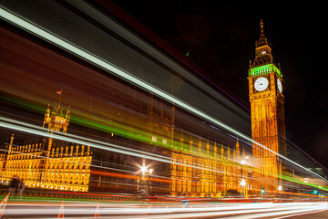 Fototapeta na wymiar The Houses of Parliament in London England UK at night with Big Ben and light trails from passing vehicles and is a popular tourism travel destination visitor attraction of the city stock photo