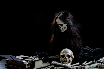 Ghostly skull typing something on table on black background. Ghost using Typewriter text with paper...