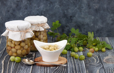 Homemade pickled gooseberries with spices in glass jars
