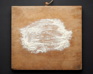 white wheat flour scattered on a wooden table