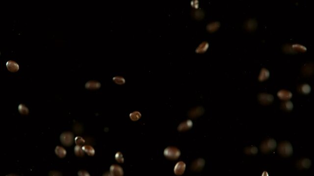 Super slow motion of coffee beans collision on black background. Filmed on high speed cinema camera, 1000 fps.