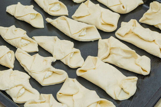 Cottage cheese rolls made from raw puff pastry, prepared for baking.