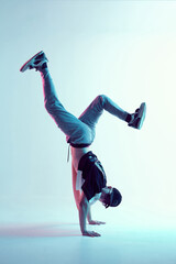 Cool young breakdancer guy stands on hands dancing hip-hop in neon light. Dance school poster