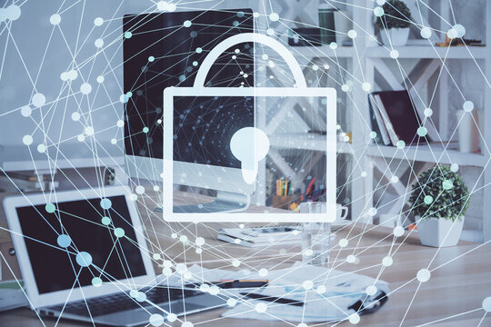 Double exposure of desktop with computer and lock icon hologram. Concept of data safety.