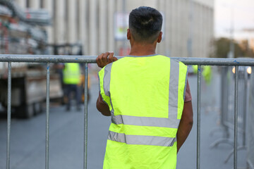 a worker in a reflective vest making a fence