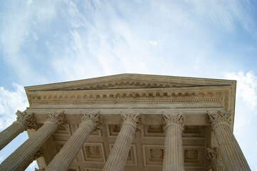 Naklejka premium The elegant maison carree in the French city of Nimes. A beautiful Roman temple. View of the dramatic Portico with it's Doric columns and Capitals.
