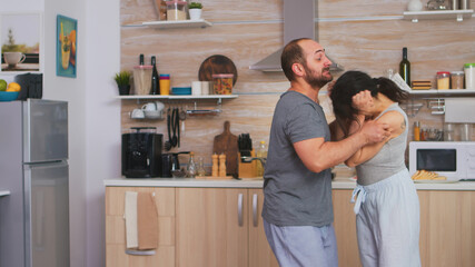 Violent husband shaking wife during disagreement at breakfast. Domestic violence threatening...