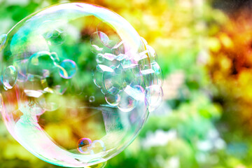 小さなシャボン玉がついた大きなしゃぼんン玉とピンクや緑のカラフル背景