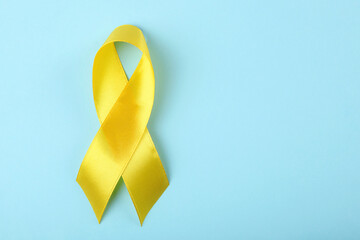 yellow ribbon symbolizing cancer in children top view

