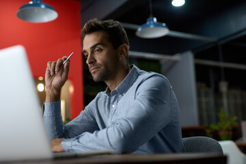 Focused young businessman working at his desk after hours