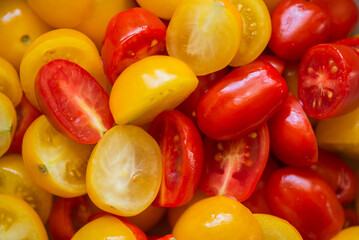 Mix of red and yellow cherry tomatoes, cut for salad