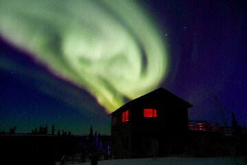 Fototapeta na wymiar Strong green aurora borealis over house in Fairbanks, Alaska