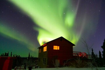 Strong green aurora borealis over house in Fairbanks, Alaska