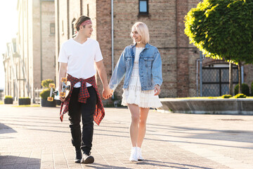 Teenage couple with a longboard during their date in a city