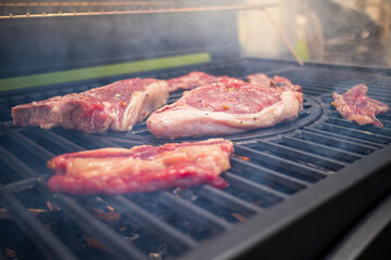 Home barbecue with charcoal in the backyard grilling steaks and other meats for carnivore diet.