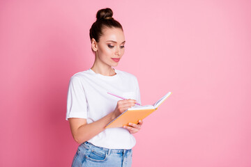 Photo of focused girl write copy book homework project wear good look clothes isolated over pink color background