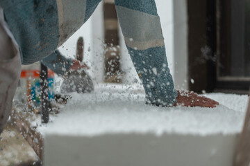 Construction worker scrapping styrofoam with a trowel