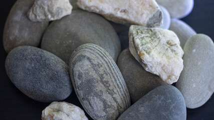 Fototapeta na wymiar smooth sea stones on an ebony background