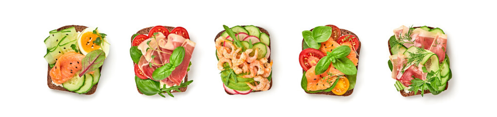 Open sandwiches with vegetables, avocado, tomato, mozzarella, egg and soft cheese. Homemade sandwich collection with salmon, ham, cucumber, radish, herbs isolated on white, top view