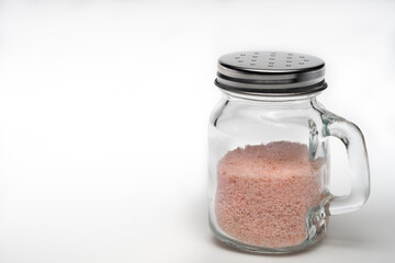 Salt shaker with Himalayan salt isolated on a white background with room for copy