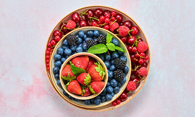 Blueberry, raspberry, blackberry, redcurrant, strawberry, cherry in bowl. Fresh blueberry, berries mix on marble. Red raspberry, blue blackberry, mint creative composition. Colorful