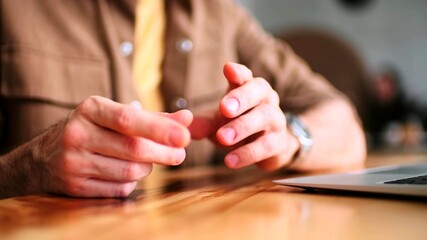 Close-up of the gestures of a man next to a laptop