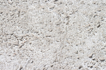 Concrete with rocks wall bumpy painted surface for cool urban grungy wallpaper or macro background