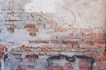 Old brick wall with dirty cement and white paint marks