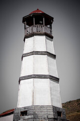 Lighthouse by the sea with houses