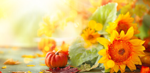 Autumn festive background with sunflowers, pumpkins and fall leaves. Concept of Thanksgiving day or Halloween with copy space