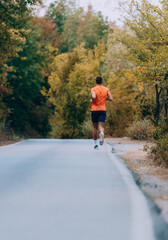 Fototapeta premium Fit handsome jogger working out for marathon outside in autumn