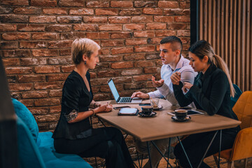 Business consultant showing business strategy on her tablet to her colleagues in a cafe