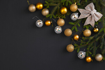 Christmas flat lay background. Decoration balls with fir branches on black background with copy space. Merry  Christmas and Happy New Year.