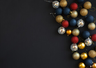 Decoration balls with fir branches on black background with copy space. Merry Christmas and Happy New Year flat lay.	
