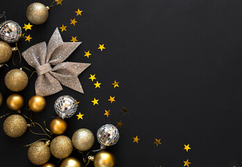 Golden Christmas flat lay decoration balls on dark black background with copy space. Merry Christmas and Happy New Year.	