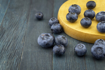 Bunch of fresh blueberries on blue rustic board