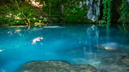 Fototapeta na wymiar Krupajsko Vrelo (The Krupaj Springs) in Serbia, beautiful water spring with waterfals and caves. Healing light blue water.