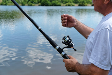 Fishing in river.A fisherman with a fishing rod on the river bank. Man fisherman catches a...