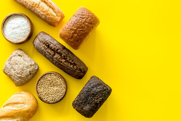 Bread near wheat ears and bowl of flour top-down space for text