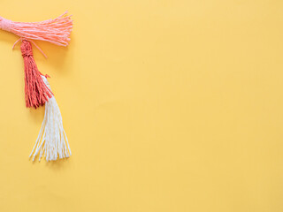 Pompoms on yellow background with copy space